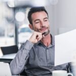 Businessman sitting in office, reading a letter