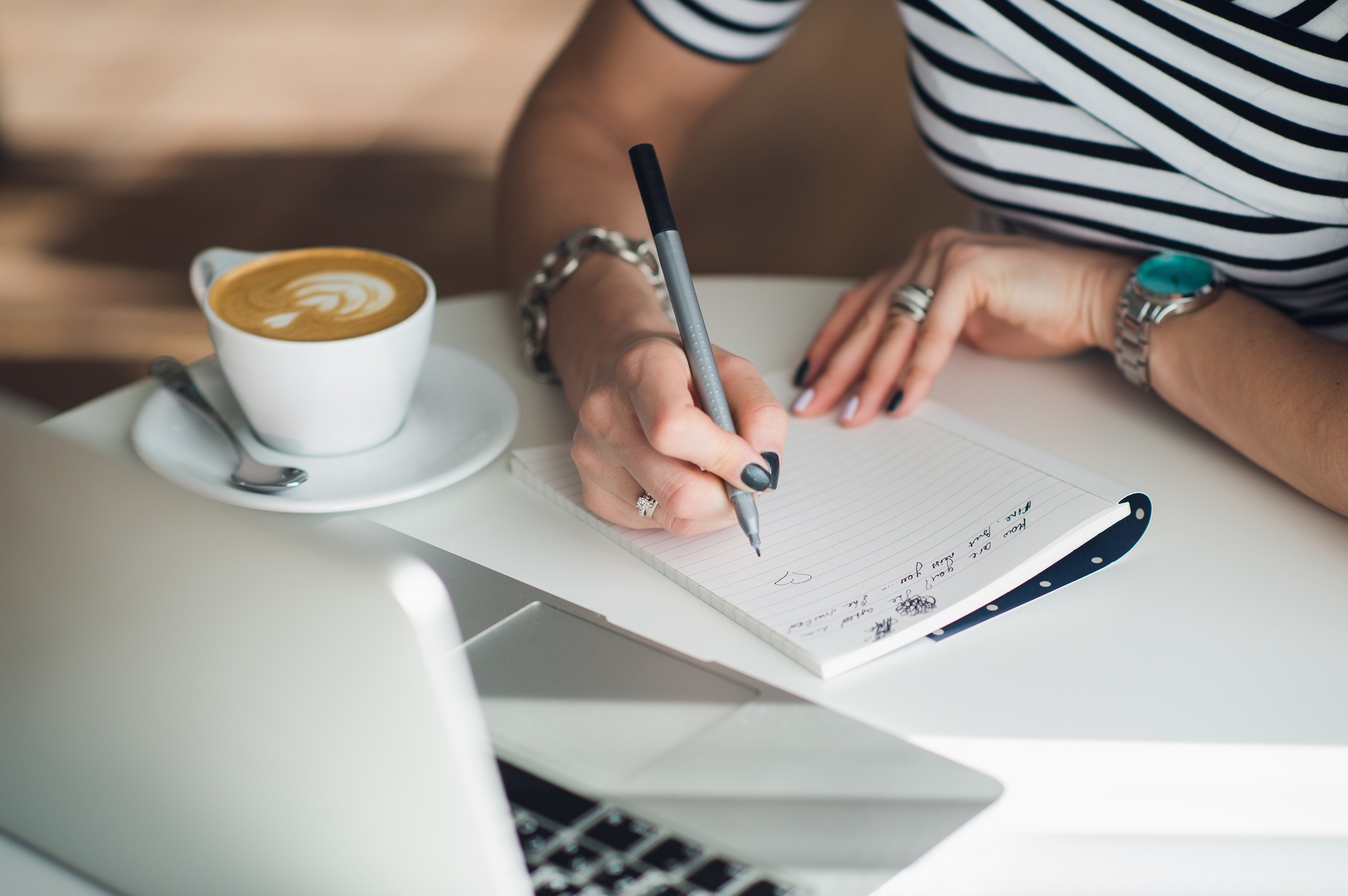 Close up portrait of a woman's hands writing a letter.