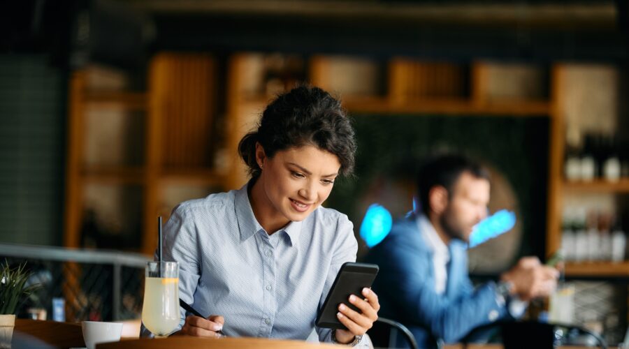 Young businesswoman reading text message on smart phone in a cafe.