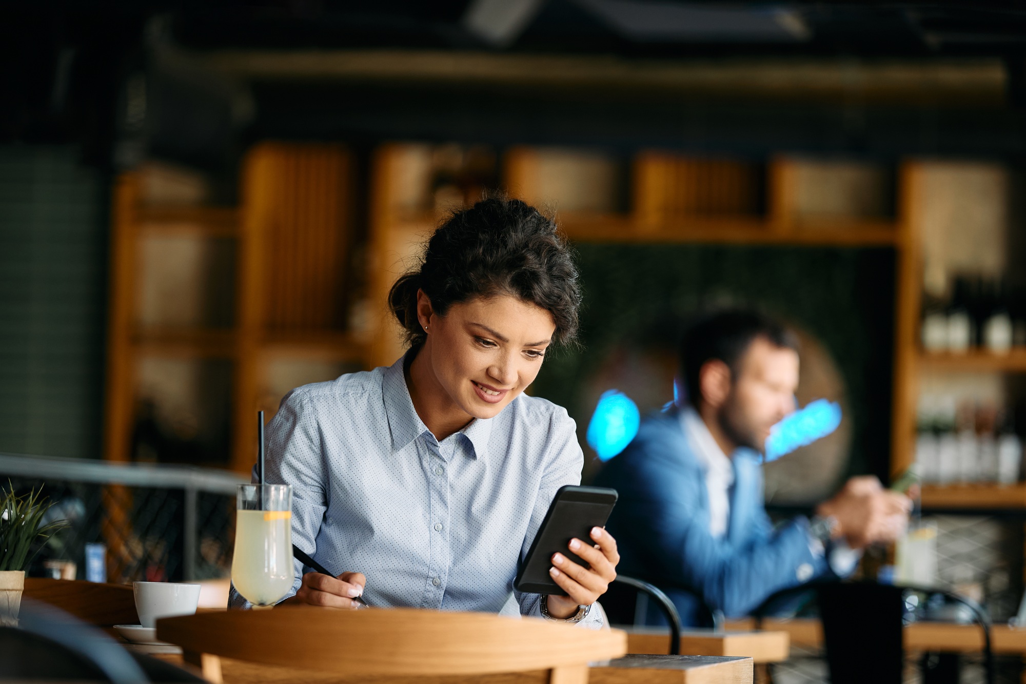 Young businesswoman reading text message on smart phone in a cafe.