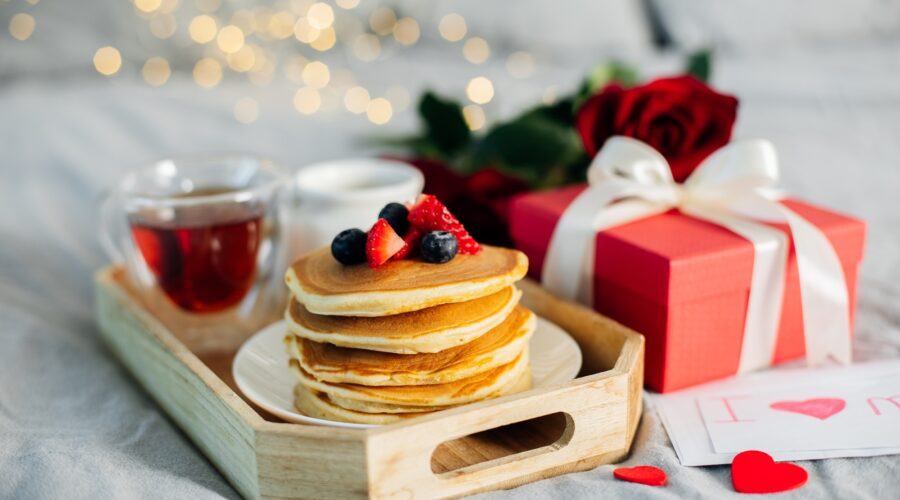 Mother's Morning breakfast on wooden tray with greeting card I love you mom, bouquqet of red roses