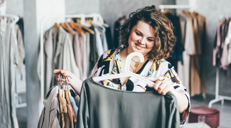 Plus Size Woman Choose Fashioned Dress in Store. Plus size women shopping.